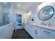 Bright bathroom with double vanity, modern lighting, and shower with tile surround, leads to bedroom at 4503 Atley Woods Se Dr, Atlanta, GA 30339