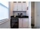 A well-lit coffee bar area features custom cabinetry, beverage cooler and sleek countertop at 4503 Atley Woods Se Dr, Atlanta, GA 30339