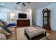 Elegant living room with a grandfather clock, a TV, a cozy sofa, and plush ottoman at 4503 Atley Woods Se Dr, Atlanta, GA 30339