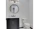 Bathroom features a dark vanity, toilet, round mirror, and marble countertop at 821 Camden Park Ct, Atlanta, GA 30342