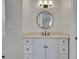 Powder room features a white vanity, round mirror, dark hardware, and neutral countertop at 821 Camden Park Ct, Atlanta, GA 30342