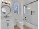 Bright bathroom with a round mirror, white vanity, and a glass shower with black trim at 821 Camden Park Ct, Atlanta, GA 30342