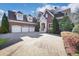 Beautiful brick home with a three-car garage, manicured landscaping, and a circular driveway at 821 Camden Park Ct, Atlanta, GA 30342