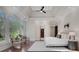 Bright primary bedroom featuring large windows, a ceiling fan, and a doorway leading to the bathroom at 821 Camden Park Ct, Atlanta, GA 30342