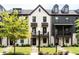 Charming townhome exteriors featuring brick and siding, complemented by manicured lawns and front walkways at 135 Climbing Ivy Cir, Fayetteville, GA 30214
