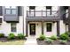 Close-up of a townhome exterior with a balcony, showcasing the brick facade and landscaping at 135 Climbing Ivy Cir, Fayetteville, GA 30214