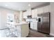 Modern kitchen features stainless steel appliances, white cabinets and countertops, plus an island with bar stool seating at 135 Climbing Ivy Cir, Fayetteville, GA 30214