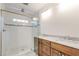 Modern bathroom with glass shower, marble vanity top, and wood cabinets at 135 Martha Ne Ave, Atlanta, GA 30317