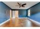 Spacious bedroom features blue walls, hardwood floors, ceiling fan, and natural light at 135 Martha Ne Ave, Atlanta, GA 30317