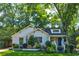 Charming home with white brick, blue door, lush lawn and mature trees at 135 Martha Ne Ave, Atlanta, GA 30317
