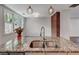 Close-up on kitchen island granite countertops, double sink, and pendant lights over the bar at 135 Martha Ne Ave, Atlanta, GA 30317
