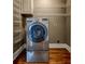 Laundry room with front load washer, hardwood floors, and wire shelving for easy organization at 135 Martha Ne Ave, Atlanta, GA 30317