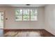Living room with large windows offering backyard views of the patio and fenced yard at 135 Martha Ne Ave, Atlanta, GA 30317