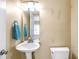 This powder room features a pedestal sink, updated lighting, and a neutral color scheme at 320 Harden St, Atlanta, GA 30312