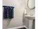 Powder room featuring pedestal sink, decorative mirror, and tiled floor at 368 Rankin Cir, Mcdonough, GA 30253