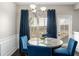 Elegant dining room with marble table, blue velvet chairs, chandelier lighting, and large window with natural light at 368 Rankin Cir, Mcdonough, GA 30253