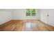 Bright bedroom features hardwood floors and a window view of a wooded landscape at 3710 Country Estate Dr Nw, Kennesaw, GA 30152