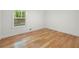 Well-lit bedroom with hardwood floors and a view of the wooded backyard at 3710 Country Estate Dr Nw, Kennesaw, GA 30152