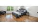 Serene bedroom boasts hardwood floors, a gray upholstered bed, and ample light at 3710 Country Estate Dr Nw, Kennesaw, GA 30152