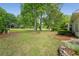 Spacious backyard with lush lawn, mature trees, and stone-bordered garden beds; great outdoor space at 2610 Links End, Roswell, GA 30076