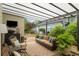 Relaxing covered patio area with comfortable seating, a TV, and lush greenery at 2610 Links End, Roswell, GA 30076