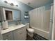 Bright bathroom featuring a shower-tub combo, a decorative mirror, and modern white cabinets at 3064 Baymount Way, Lawrenceville, GA 30043