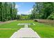 Professionally landscaped backyard featuring a geometric in-ground pool and lush green lawn with a privacy fence at 103 Maddox Rd, Buford, GA 30518