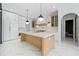 Spacious kitchen featuring a large island, white cabinetry, stainless steel appliances, and modern lighting at 103 Maddox Rd, Buford, GA 30518