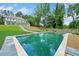 The backyard features an in-ground geometric pool, privacy fence, and lush landscaping. View of the main house in the background at 103 Maddox Rd, Buford, GA 30518