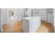 Bright walk-in closet with custom shelving, center island, and hardwood flooring at 103 Maddox Rd, Buford, GA 30518