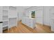 Spacious walk-in closet featuring hardwood floors, shelving and a center island with drawers at 103 Maddox Rd, Buford, GA 30518