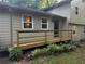Charming home's entrance features a freshly stained wood ramp, leading to the inviting front door, with manicured landscaping at 3474 Leaf Land Ct, Duluth, GA 30097
