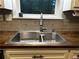 A close up view of a stainless steel kitchen sink, with butcher block countertops and grey tile backsplash at 3474 Leaf Land Ct, Duluth, GA 30097