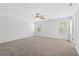 A bright bedroom with plush carpeting, a ceiling fan, and natural light from two windows at 4778 Moonstone Trce, Kennesaw, GA 30144