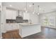 Modern kitchen with island, pendant lighting, white cabinets, and backsplash at 4778 Moonstone Trce, Kennesaw, GA 30144