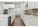 Well-lit kitchen featuring white cabinets, stainless steel appliances, and an island with a sink at 4778 Moonstone Trce, Kennesaw, GA 30144