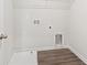Laundry room with white walls, wood look floors, washer/dryer hookups and a utility sink at 4778 Moonstone Trce, Kennesaw, GA 30144