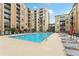 Beautiful outdoor swimming pool with lounge chairs and umbrellas, surrounded by the apartment complex at 711 Cosmopolitan Ne Dr # 802, Atlanta, GA 30324