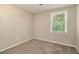 Bedroom featuring a window overlooking a lush, green landscape and plush carpeting at 120 E Cainwood E Ct, Atlanta, GA 30349