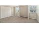 Neutral bedroom with carpet flooring and a closet with double doors and two windows at 120 E Cainwood E Ct, Atlanta, GA 30349