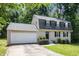 Charming two-story home featuring a gray brick facade, black shutters, and an attached garage at 120 E Cainwood E Ct, Atlanta, GA 30349