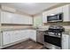 Modern kitchen featuring white cabinets, stainless steel appliances, granite countertops, and wood-look floors at 120 E Cainwood E Ct, Atlanta, GA 30349