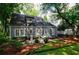 Exterior shot of the house with a stone patio, manicured landscaping, and mature trees at 2811 Alpine Ne Rd, Atlanta, GA 30305