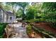 Picturesque backyard with a stone patio, lush garden beds, and serene wooded views at 2811 Alpine Ne Rd, Atlanta, GA 30305
