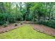 Wide backyard with moss lawn, surrounded by woods and landscaping, creates a private outdoor space at 2811 Alpine Ne Rd, Atlanta, GA 30305