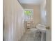Bright bathroom with a white shower curtain, toilet, sink, and a window to let in natural light at 2811 Alpine Ne Rd, Atlanta, GA 30305