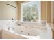 Jetted bathtub with tile surround and window with view at 412 Middlebrooke St, Canton, GA 30115
