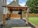 Wooden gazebo with curtains and TV mounted on post with concrete base in green back yard at 412 Middlebrooke St, Canton, GA 30115