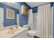 A stylish bathroom features blue walls, a modern vanity, and a shower with a curtain at 5807 Mitchell Chase Trl, Mableton, GA 30126