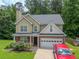 Charming two-story home with a brick and siding exterior, a well-manicured lawn, and an attached two-car garage at 5807 Mitchell Chase Trl, Mableton, GA 30126